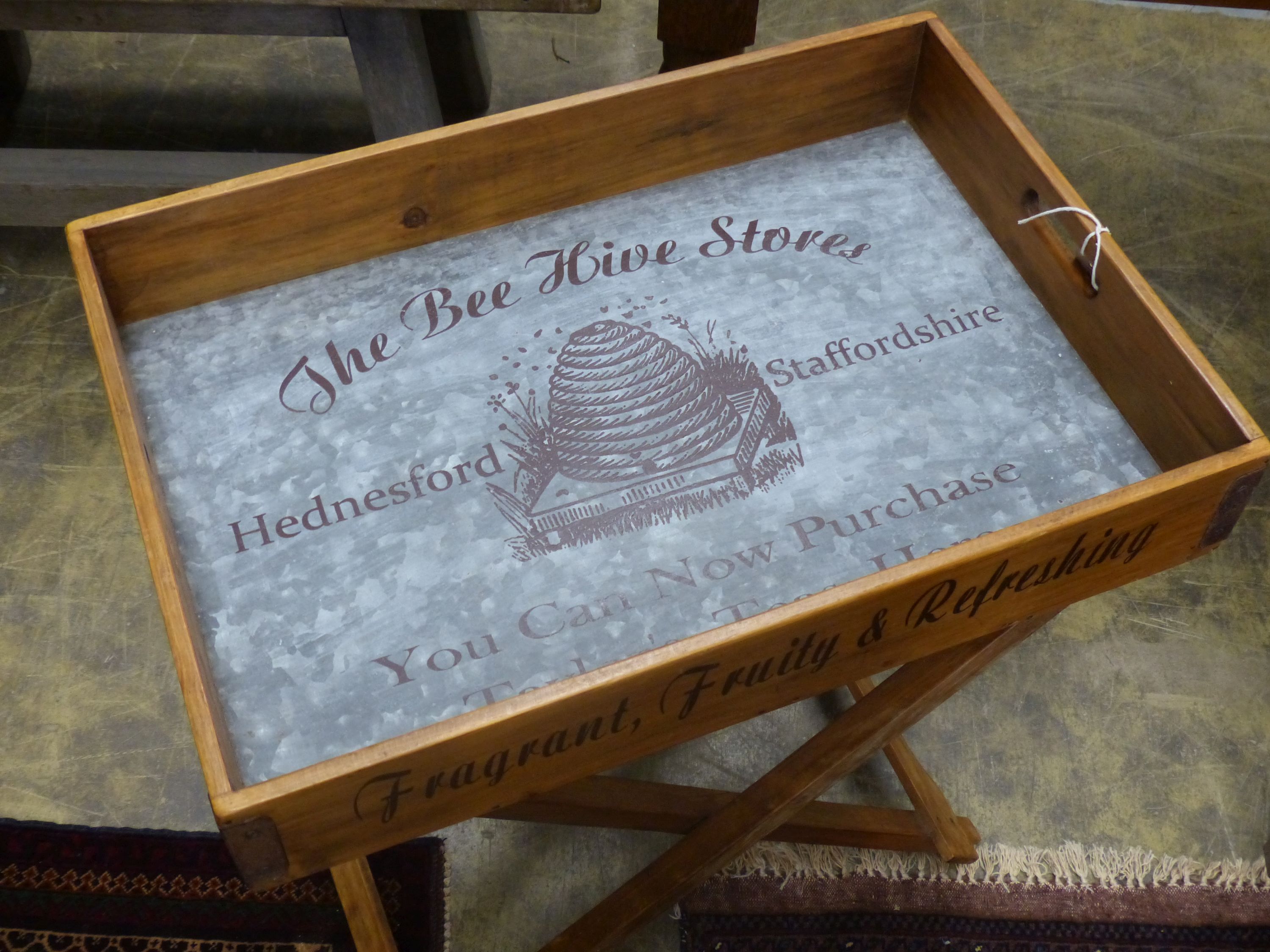 'The Bee Hive Stores', a rectangular wooden produce display tray on folding stand, width 65cm, depth 44cm, height 78cm